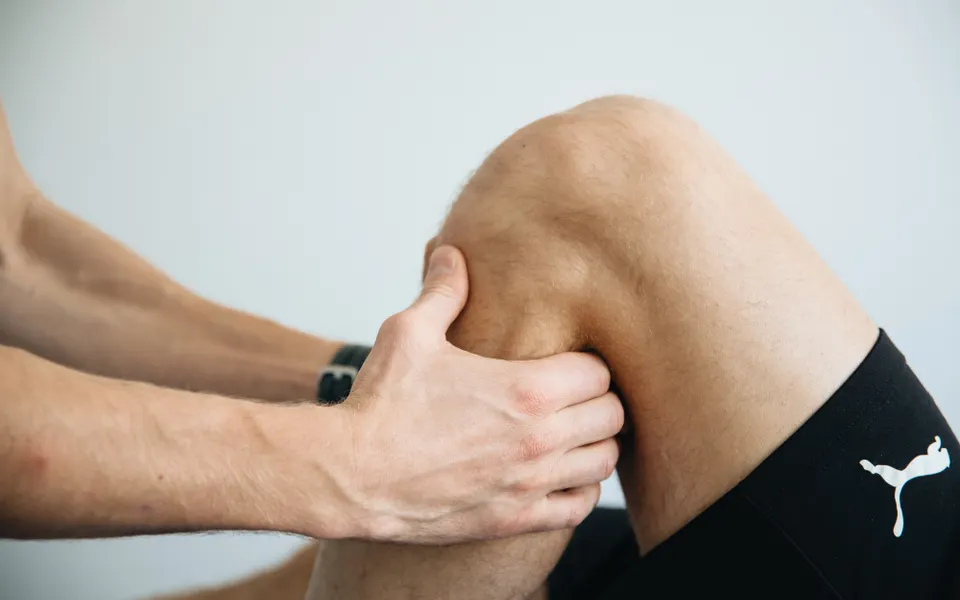 Therapist working on a patient's knee during post-surgical rehabilitation