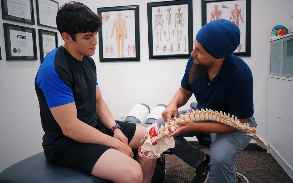 Doctor explaining a treatment plan to a patient using a spine model
