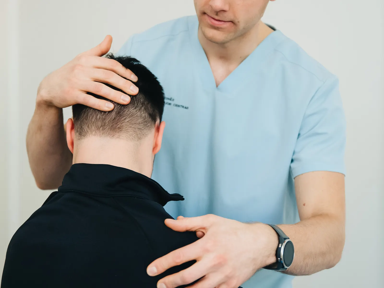 Physiotherapist assessing a patient's neck and shoulders after a motor vehicle accident
