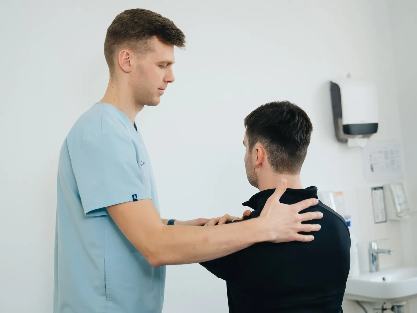 Physiotherapist treating a patient's shoulder injury in a clinic